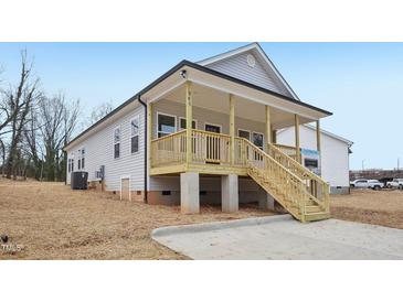 Charming home with a welcoming covered front porch and natural wood stairs at 815 Graham St, Burlington, NC 27217