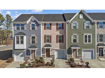 Charming townhomes featuring varied siding colors, attached garages, and well-maintained landscaping at 905 Arnold Place Dr, Fuquay Varina, NC 27526