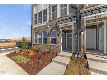 Charming brick townhome featuring a welcoming entrance and landscaped garden at 1241 S Blount Street # 201, Raleigh, NC 27601