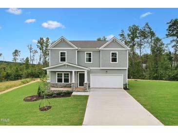 Two story home with neutral siding, a two car garage, a covered front porch and professionally landscaped yard at 181 Cribbs Ln, Middlesex, NC 27557