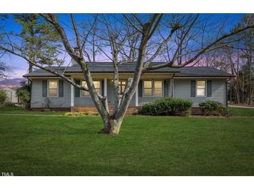 Charming single-story home with gray siding, complemented by a mature tree and expansive lawn at 245 Cedar Crk Rd, Franklinton, NC 27525