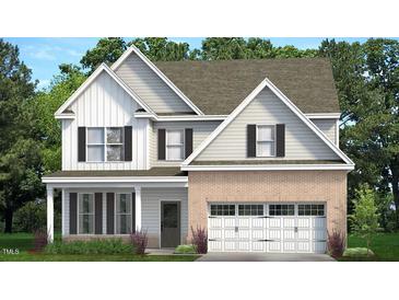 Charming new two-story home with white siding, brick accents, and attached two car garage at 504 Lemon Daisy Ln, Knightdale, NC 27545