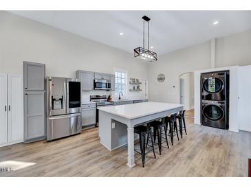 Bright kitchen features a large island with seating, stainless steel appliances, and modern light fixtures at 57 Lowell Ct, Smithfield, NC 27577