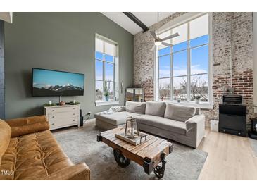 Bright living room with exposed brick, oversized windows, and comfortable seating with rustic coffee table at 614 Capital Blvd # 229, Raleigh, NC 27603