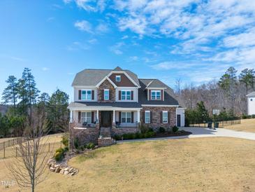 Charming two-story home with a manicured lawn, stone accents, and a welcoming front porch at 158 Futrell Ridge Ct, Chapel Hill, NC 27517