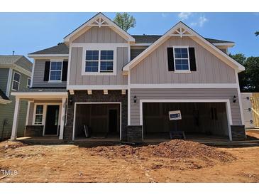 New two-story home with attached two-car garage, and a combination of gray siding and stone facade at 235 Augusta Pond Way # 161, Raleigh, NC 27603