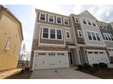 New construction townhouse with a two-car garage and stone and siding facade at 2715 Hunter Woods Dr # 562, Apex, NC 27502
