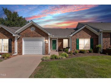 Charming brick home with a one-car garage, manicured lawn, and inviting green door at 3027 Maple Ave # D2, Burlington, NC 27215