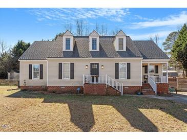 Charming home featuring dormer windows, a brick foundation, and a welcoming front porch with white railings at 400 Cedarmere Dr, Wendell, NC 27591