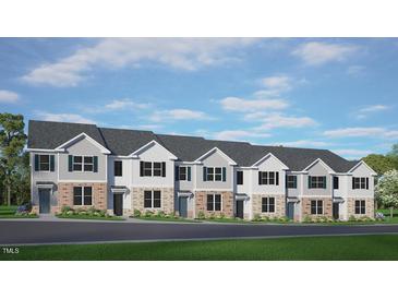 New townhome community showcasing brick and light siding with dark shutters and a beautifully landscaped front yard at 521 Old Battle Bridge Rd, Wendell, NC 27591