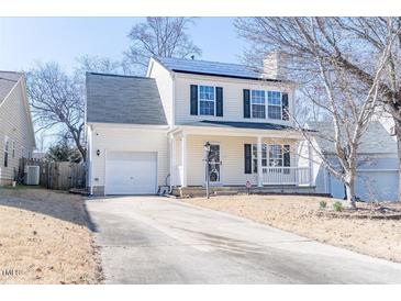 Charming two-story home featuring a front porch, attached garage, and well-maintained landscaping at 117 Crabwall Ct, Holly Springs, NC 27540