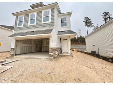 Two-story home featuring a two-car garage, white siding, shingle details, and a welcoming front door at 132 Muskogee Rd # 58, Angier, NC 27501