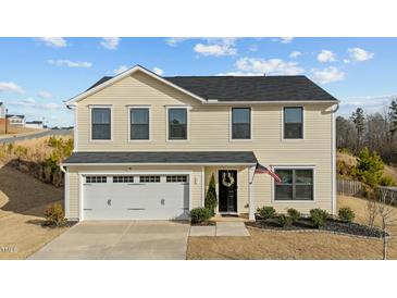 Charming two-story home with a well-manicured lawn, attached garage and welcoming front porch at 17 Donatella Way, Angier, NC 27501
