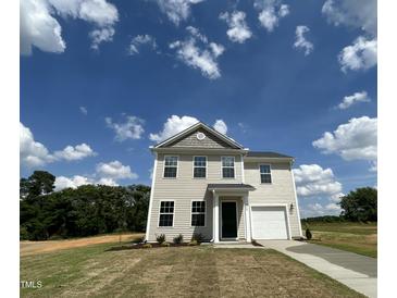 Charming two-story home featuring vinyl siding, an attached garage, and a well-manicured lawn at 260 Johnson Ridge Way, Four Oaks, NC 27524