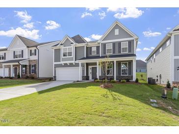 Beautiful gray two-story home featuring manicured lawn, a two-car garage, and a classic covered front porch at 267 N Maple Walk Dr # 217, Garner, NC 27529