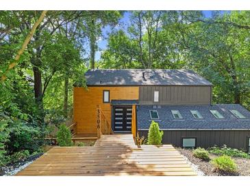 Unique exterior view of home with wood and dark siding, natural landscaping, and a wood deck entry at 3506 Bellevue Rd, Raleigh, NC 27609