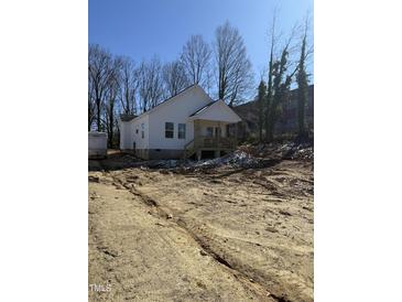 View of new construction featuring white siding, covered porch, and unfinished yard at 620 Gilmer St, Burlington, NC 27217