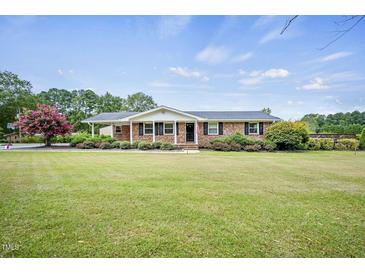 Charming brick ranch-style home with a well-manicured lawn and lush landscaping at 1687 Galilee Rd, Smithfield, NC 27577