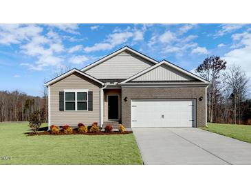 Charming single-story home with brick and siding exterior, complemented by a well-maintained front lawn at 1749 Post Oak Dr, Haw River, NC 27258