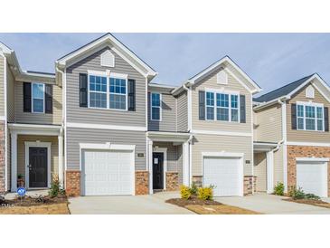 Charming townhouse featuring an attached one car garage and neutral siding at 1914 Frost Dr, Haw River, NC 27258