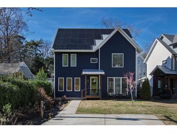 Beautiful two-story home with solar panels, a manicured lawn, and large windows offering plenty of natural light at 309 Taylor St, Raleigh, NC 27607