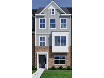 Charming townhouse showcasing a blend of brick and gray siding for an appealing exterior at 312 Chesapeak Commons St # 144, Garner, NC 27529