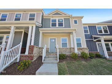 Charming townhome featuring a light yellow exterior with a welcoming covered front porch at 3725 Rosebush Dr, Zebulon, NC 27597