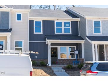 Two story townhome with blue siding, white trim, and small porch area at 3727 Rosebush Dr, Zebulon, NC 27597