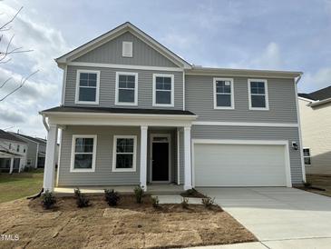 Charming two-story home with a grey exterior, a two-car garage, and a well-maintained front yard at 4120 Shadbush St, Raleigh, NC 27616