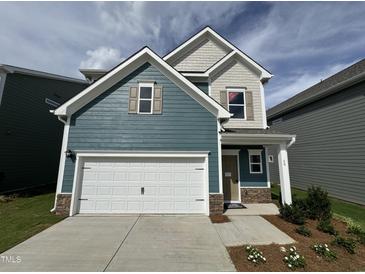 Charming two-story home featuring a two-car garage, craftsman-style details, and a welcoming front porch at 60 Commons Cir, Clayton, NC 27520