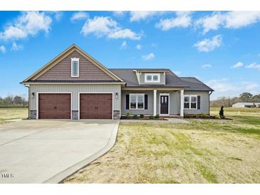 Charming home featuring a two-car garage, craftsman details, and manicured landscaping at 618 Tart Town Rd, Dunn, NC 28334
