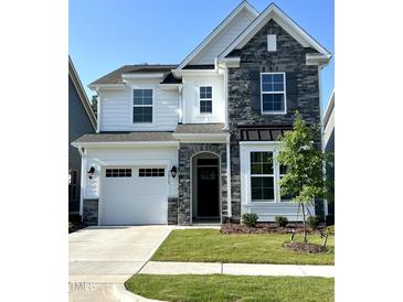 Beautiful two-story home with a stone facade and manicured lawn showcases classic design at 1013 Greatland Road, Durham, NC 27703