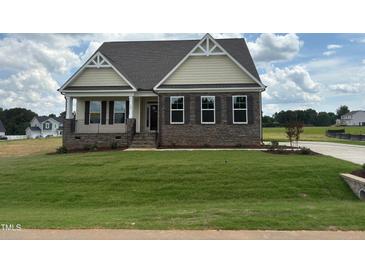 Charming single-story home with stone accents, a well-manicured lawn, and welcoming curb appeal at 190 Sage Ln # 015, Four Oaks, NC 27524