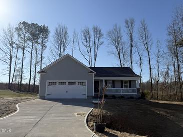 Charming single-story home with attached garage and inviting front porch, set against a backdrop of mature trees at 271 Starry Sky Dr, Benson, NC 27504