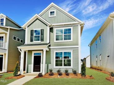 Charming two-story home with a well-manicured lawn and delightful curb appeal on a sunny day at 44 Blue Iris Pkwy # 121, Clayton, NC 27520