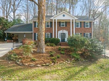 Charming brick home with white columns, black shutters, and a well-manicured front yard at 5620 Winthrop Dr, Raleigh, NC 27612