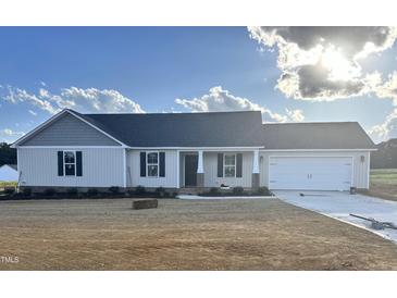 Charming single-story home with a manicured lawn, an attached two-car garage and a classic design at 59 N Movado Trl, Kenly, NC 27542