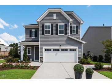 Charming two-story home with gray siding, black shutters, attached garage, and well-manicured lawn at 625 Emerald Bay Cir, Raleigh, NC 27610