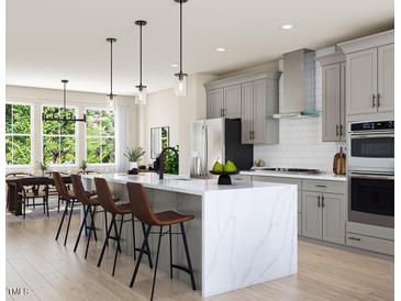 Bright kitchen with stainless steel appliances, island with seating and sleek countertops at 806 Hyperion Aly, Wake Forest, NC 27587