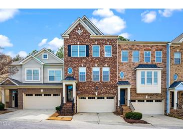 Charming brick townhome with blue shutters, an attached garage and manicured lawn at 8124 Primanti Blvd, Raleigh, NC 27612