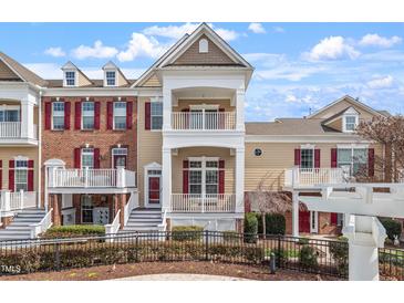 Charming townhome with a double balcony and landscaped yard featuring a black metal fence at 10321 Sablewood Dr # 108, Raleigh, NC 27617
