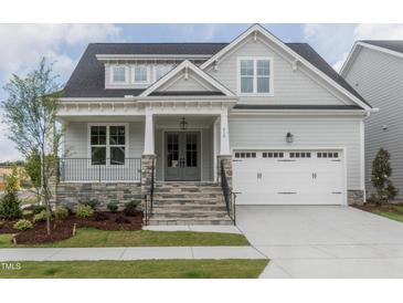 Charming craftsman home featuring stone accents, a two-car garage, and a welcoming covered front porch at 104 Bearwallow Forest Way, Wendell, NC 27591