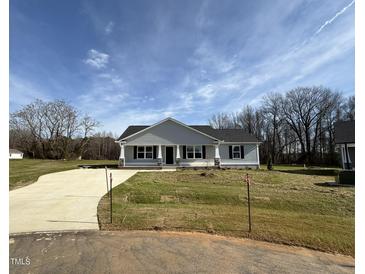 Charming single-story home with a well-manicured lawn, concrete driveway, and inviting front porch at 197 Pate Landing Dr, Selma, NC 27576