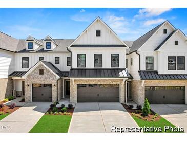 Charming townhome exterior boasts brick accents, a two-car garage, and a well-manicured lawn at 46 N District Ave # 251, Clayton, NC 27527