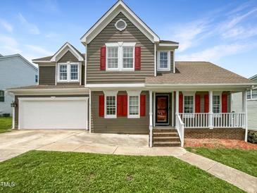 Charming two-story home with a manicured lawn, attached garage, and inviting front porch at 5317 Tifton Dr, Raleigh, NC 27610