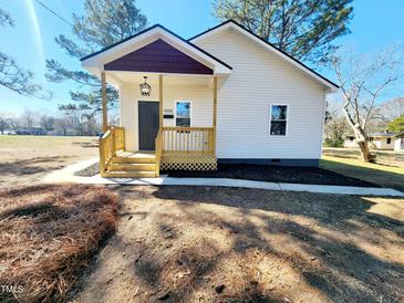 Charming single-story home featuring a cozy front porch and freshly landscaped yard at 606 E Pearsall St, Dunn, NC 28334