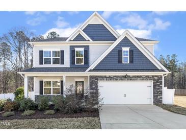 Charming two-story home featuring a stone-accented facade, white garage door, and well-manicured landscaping at 192 Springhill Ln, Garner, NC 27529