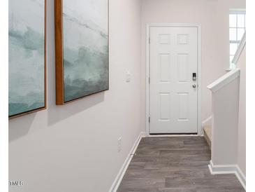 View of the hallway with grey flooring and a white door at 247 Perseus St, Angier, NC 27501