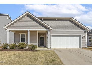 Charming single-story home with gray siding, white trim, a manicured lawn, and an attached two-car garage at 3333 Sandy Meadows Dr, Fuquay Varina, NC 27526