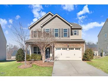 Charming two-story home featuring a stone facade, attached two-car garage, and beautifully landscaped front yard at 346 Naples Ln, Clayton, NC 27527